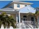 Two-story house with light yellow walls, blue accents, and a metal roof at 727 Holly Rd, Anna Maria, FL 34216