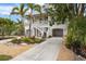 Two-story house with a charming exterior, landscaping, and driveway at 727 Holly Rd, Anna Maria, FL 34216