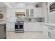 White kitchen with light blue backsplash and stainless steel appliances at 727 Holly Rd, Anna Maria, FL 34216