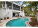 Inviting kidney shaped pool with surrounding patio and spiral staircase at 727 Holly Rd, Anna Maria, FL 34216