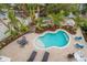 Freeform swimming pool with a patio and lounge chairs at 727 Holly Rd, Anna Maria, FL 34216