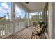 Relaxing screened porch with wooden deck and outdoor seating at 727 Holly Rd, Anna Maria, FL 34216