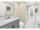 Modern bathroom with marble vanity, walk-in shower, and private access to backyard at 752 Tropical Cir, Sarasota, FL 34242