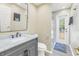 Modern bathroom with marble vanity, walk-in shower, and private access to backyard at 752 Tropical Cir, Sarasota, FL 34242