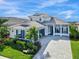 Two-story home with gray roof, blue shutters, and paver driveway at 8050 Redonda Loop, Lakewood Ranch, FL 34202