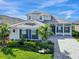 Two-story home with gray roof, blue shutters, and paver driveway at 8050 Redonda Loop, Lakewood Ranch, FL 34202