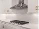 Kitchen detail showcasing gas cooktop and white subway tile at 8050 Redonda Loop, Lakewood Ranch, FL 34202