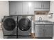 Laundry room with gray cabinets and matching washer and dryer at 8050 Redonda Loop, Lakewood Ranch, FL 34202