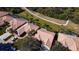 Aerial view showing houses with tile roofs and a golf cart path at 8282 Parkside Dr, Englewood, FL 34224