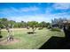 Backyard with grass, trees, and a view of a golf course at 8282 Parkside Dr, Englewood, FL 34224