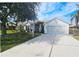 Single-story home with a tile roof, attached garage, and landscaped lawn at 8282 Parkside Dr, Englewood, FL 34224