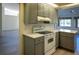 Updated kitchen with gray cabinets and white appliances at 8282 Parkside Dr, Englewood, FL 34224