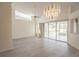 Spacious living room with large windows, high ceilings and a chandelier at 8282 Parkside Dr, Englewood, FL 34224