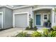 Townhome entrance with teal door, landscaping, and attached garage at 8533 Lunar Skye St, Sarasota, FL 34241
