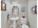 Clean bathroom with pedestal sink, toilet, and decorative accents at 9203 Griggs Rd # B304, Englewood, FL 34224