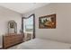 Well-lit bedroom with dresser, chair, and a large window at 9203 Griggs Rd # B304, Englewood, FL 34224
