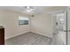 Bedroom with large window, ceiling fan, and wood-look floors at 104 Capri Isles Blvd # 112, Venice, FL 34292