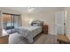 Cozy bedroom with wood-look floors and private balcony access at 104 Capri Isles Blvd # 112, Venice, FL 34292