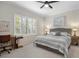 Spacious main bedroom with a king-size bed, built-in workspace, and neutral decor at 12199 Sebring Ln, Venice, FL 34293