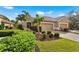 Tan two-car garage home with lush landscaping and a brick driveway at 12199 Sebring Ln, Venice, FL 34293