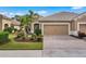 Two-story home with tan exterior, two-car garage, and well-manicured lawn at 12199 Sebring Ln, Venice, FL 34293