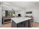 Modern kitchen island with white cabinets and marble countertops, open to living area at 12199 Sebring Ln, Venice, FL 34293