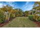 Landscaped backyard with tropical plants and grassy area at 12240 Whisper Lake Dr, Bradenton, FL 34211