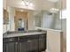 Bathroom with granite countertop, dark cabinets and a glass shower at 12240 Whisper Lake Dr, Bradenton, FL 34211