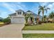 White one-story house with a two-car garage, landscaping, and palm trees at 12240 Whisper Lake Dr, Bradenton, FL 34211