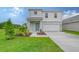 Two-story house with light gray siding, a two-car garage, and a landscaped lawn at 13115 Cedar Elm Lane, Parrish, FL 34219