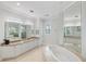 Spa-like bathroom with a large soaking tub and dual vanities at 144 N Casey Key Rd, Osprey, FL 34229