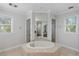 Spa-like bathroom featuring a large soaking tub and and sinks at 144 N Casey Key Rd, Osprey, FL 34229