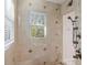 Bright bathroom with walk-in shower, tiled walls, and window at 144 N Casey Key Rd, Osprey, FL 34229