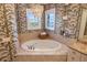 Bathroom with a large soaking tub and patterned wallpaper at 144 N Casey Key Rd, Osprey, FL 34229
