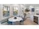 Modern kitchen with white cabinetry, breakfast nook, and water views at 144 N Casey Key Rd, Osprey, FL 34229