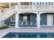 Outdoor kitchen with bar seating and poolside access at 144 N Casey Key Rd, Osprey, FL 34229