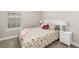Bedroom with floral bedding, nightstand, and a window with blinds at 16127 Fortezza Dr, Bradenton, FL 34211