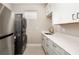 Laundry room with stacked washer and dryer, a sink, and white cabinets at 16127 Fortezza Dr, Bradenton, FL 34211