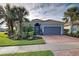 Single-story home with gray garage door, brick paver driveway, and lush landscaping at 19451 Quisto St, Venice, FL 34293