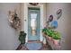 Inviting front entry with a teal door, decorative wall art, and potted plants at 19451 Quisto St, Venice, FL 34293