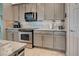 Kitchen features gray cabinets, granite countertops, and stainless steel appliances at 19451 Quisto St, Venice, FL 34293