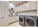 Laundry room with modern washer and dryer, granite countertop, and white cabinets at 19451 Quisto St, Venice, FL 34293