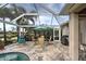 Covered patio with dining area and outdoor grill overlooking the pool at 19451 Quisto St, Venice, FL 34293