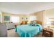 Bedroom with a teal bedspread, wicker chair, and light-colored dresser at 2107 Palma Sola Blvd # 59, Bradenton, FL 34209