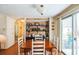 Cozy dining area with wooden table, white chairs, and built-in shelving at 2107 Palma Sola Blvd # 59, Bradenton, FL 34209