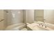 Bathroom boasts gray tile, a white vanity, and a bathtub at 21628 Lake Placid Way, Venice, FL 34293