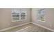 Well-lit bedroom with tile flooring and two windows at 21628 Lake Placid Way, Venice, FL 34293