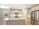 Modern kitchen with white cabinets, quartz countertops, and stainless steel appliances at 21628 Lake Placid Way, Venice, FL 34293