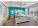 Main bedroom with a white bed frame, teal accent wall, and ceiling fan at 3206 Hilltop Cir, Bradenton, FL 34211