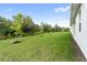 Landscaped backyard with grassy area and young trees at 3425 Dryden St, North Port, FL 34288